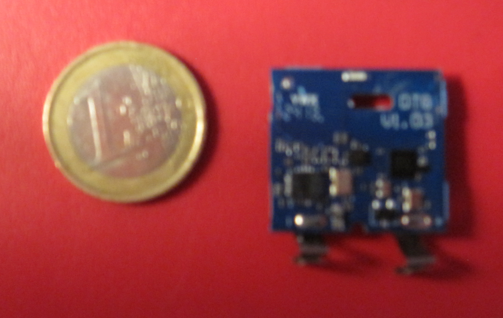 Le PCB du détecteur Netatmo, avec ses piles, comparé à une pièce d'un euro, côté composants.